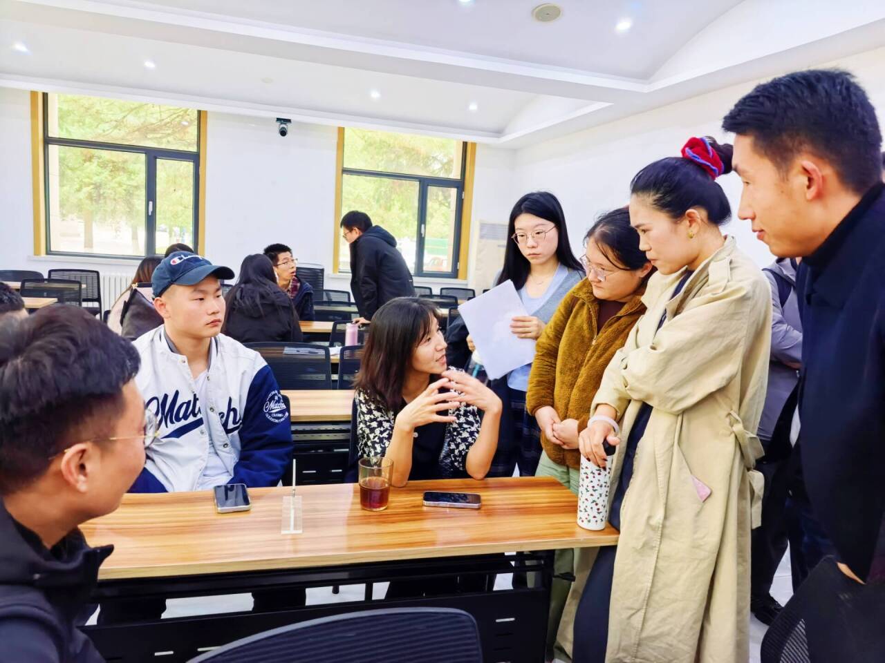 一群人看着桌子上中度可信度描述已自动生成